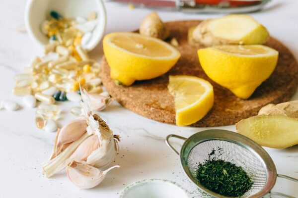 slices of lemon and ginger near garlic cloves on a flat surface