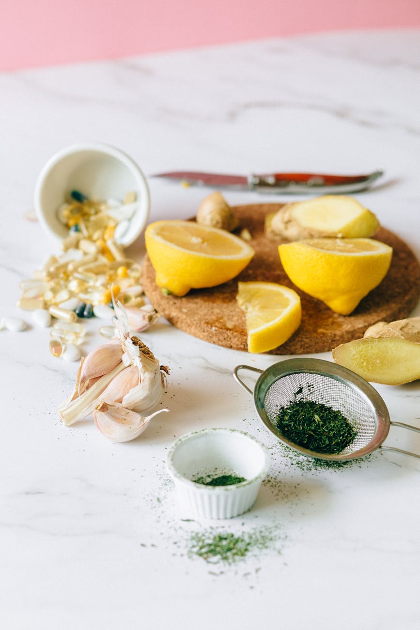 slices of lemon and ginger near garlic cloves on a flat surface