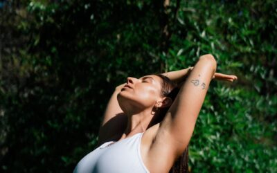 woman in white sports bra and yellow leggings stretching